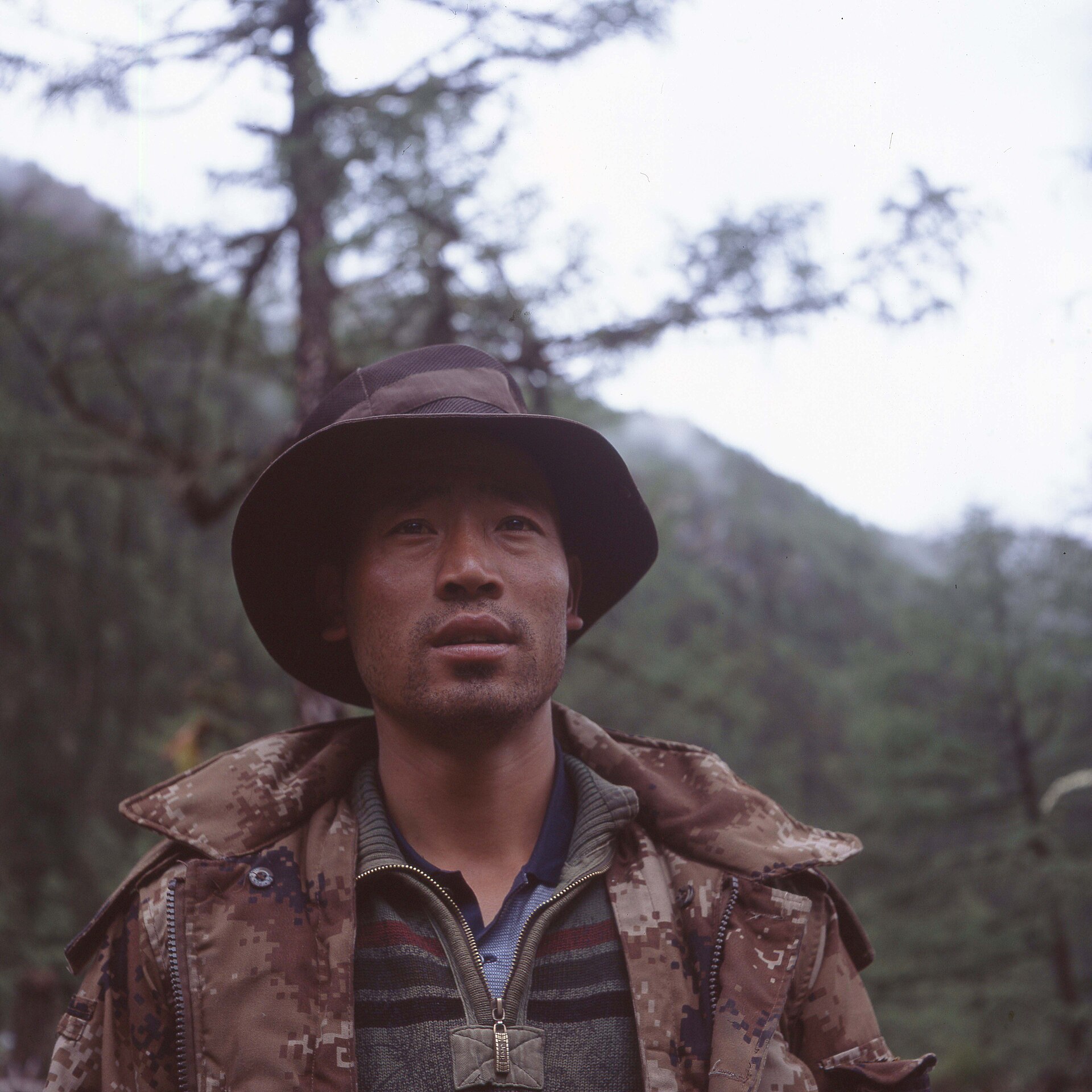亚丁 Trek 中向导牵马行进在山路上